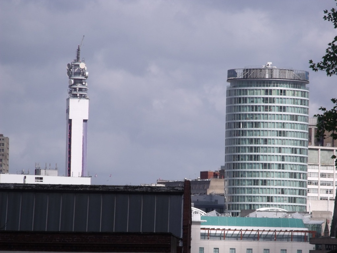 Moderna landmärken i Växjö, inklusive ett telekommunikationstorn och kontorsbyggnaden Icon Växjö, som illustrerar stadens dynamiska utveckling och närhet till grönområden.